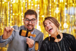 Couple over gold with photo booth accessories on party