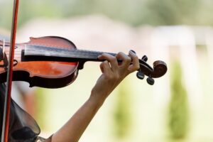 The hand of a violinist. musician performing at an outdoor wedding. Curl with violin neck