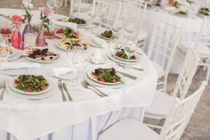 The inside of a massive white wedding tent with tables and chairs already in position